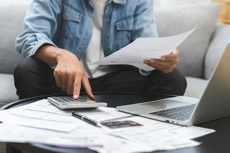 Man calculating amounts looking at paperwork