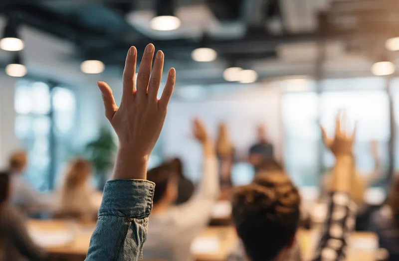 Person raising hand in group of people