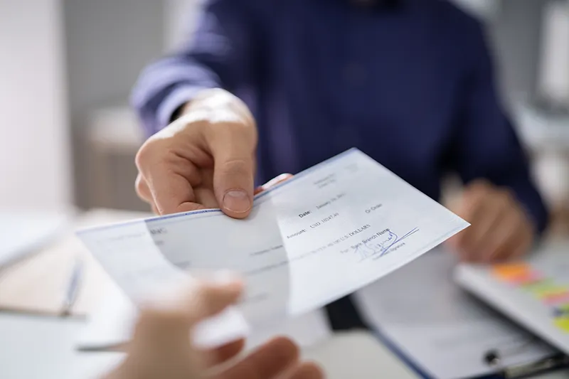 Personal injury lawyer handing client check