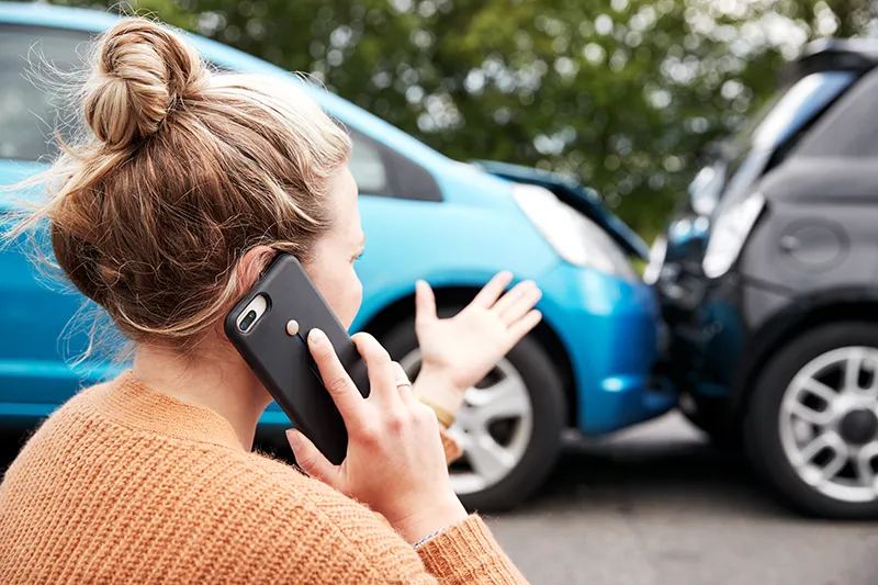 Woman on the phone after a car crash